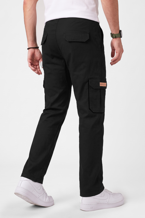 A person shown from the back wearing black cargo pants, a white t-shirt, and white sneakers against a clean white studio background.